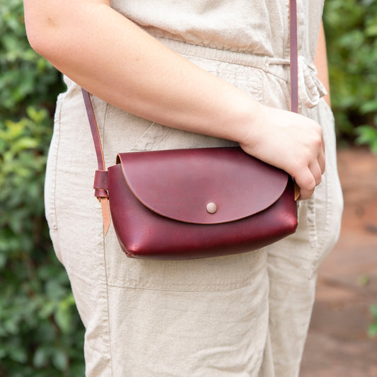 Little Jane leather crossbody purse in eggplant full grain leather worn crossbody with adjustable strap and snap closure