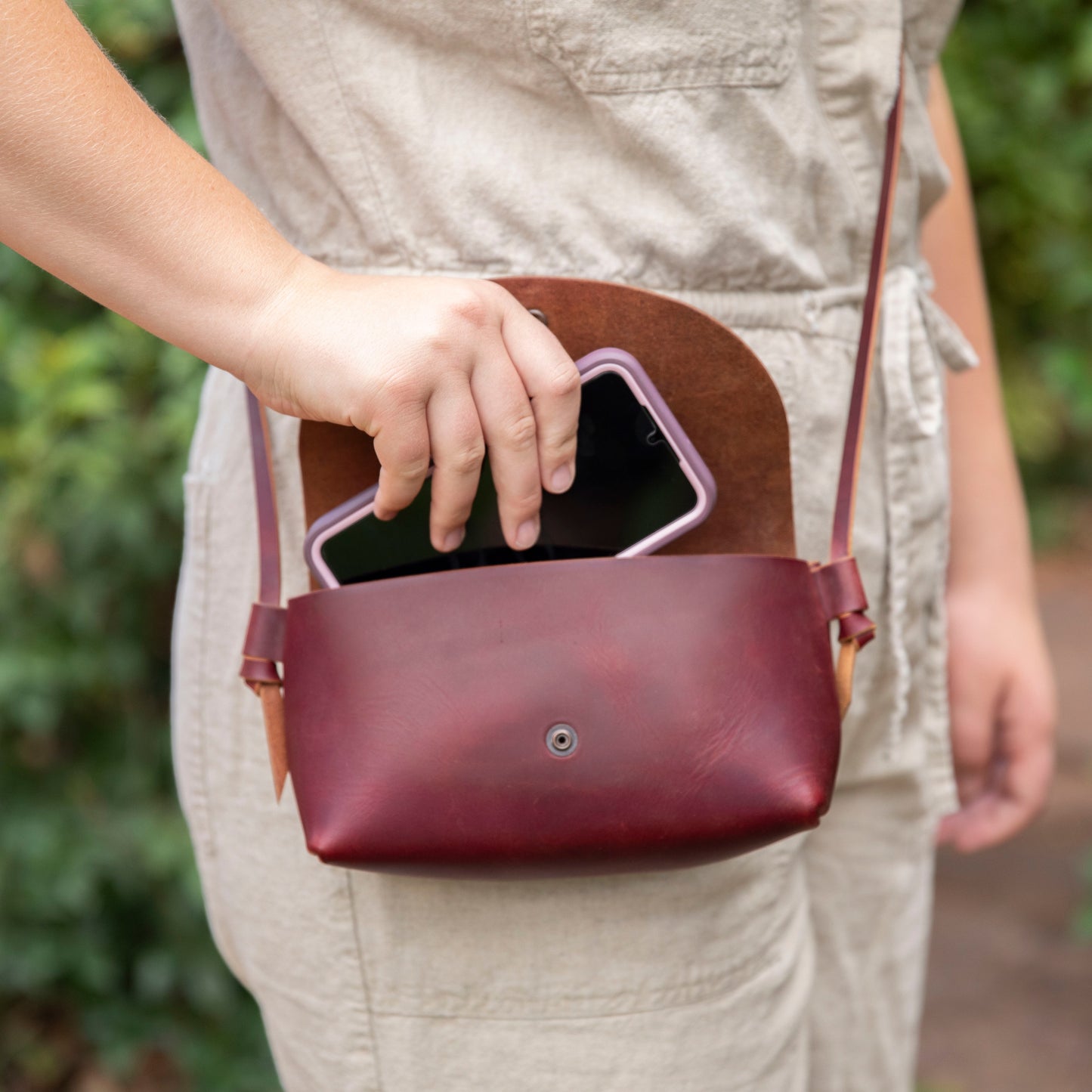 Little Jane leather crossbody purse showing phone inside for size reference in eggplant full grain leather