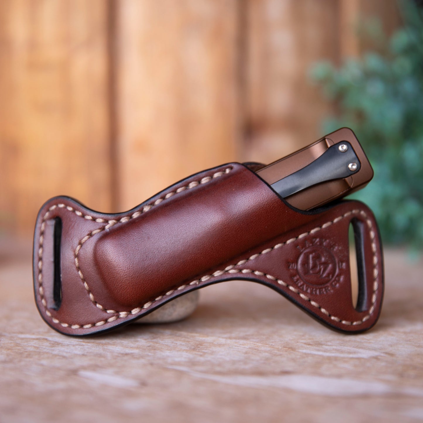 Brown leather flashlight in sheath with a blurred background