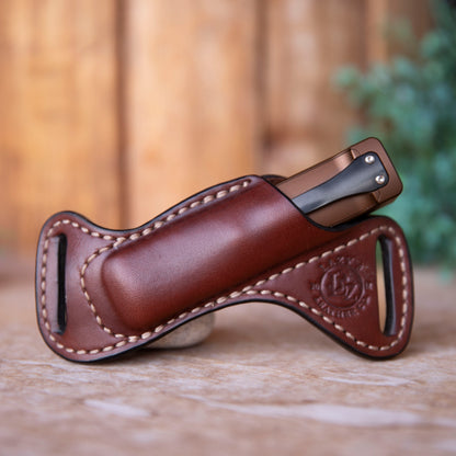 Brown leather flashlight in sheath with a blurred background