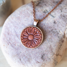 Load image into Gallery viewer, Daisy stamped leather necklace mounted in antique copper pendant and has a matching chain made by lazy 3 leather co.