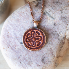 Load image into Gallery viewer, Flower stamped leather necklace mounted in antique copper pendant and has a matching chain made by lazy 3 leather co.