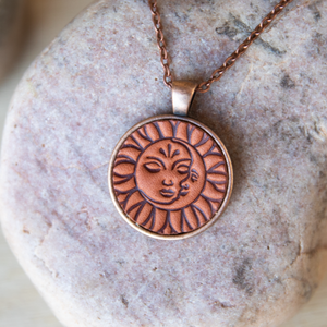Sun and Moon  stamped leather necklace mounted in antique copper pendant and has a matching chain made by lazy 3 leather co.