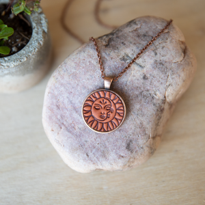 Sun and Moon stamped leather necklace mounted in antique copper pendant and has a matching chain made by lazy 3 leather co.