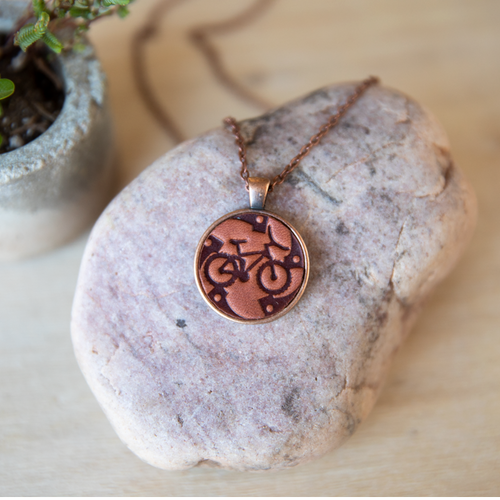 Bike gear leather necklace mounted in antique copper pendant and has a matching chain made by lazy 3 leather co.