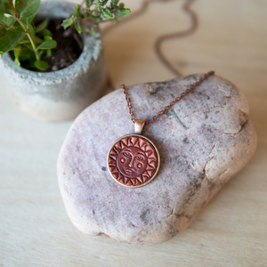 Sun and moon stamped leather necklace mounted in antique copper pendant and has a matching chain made by lazy 3 leather co.